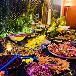 Buffet am Abend mit vielen Schalen, Platten und Pflanzen