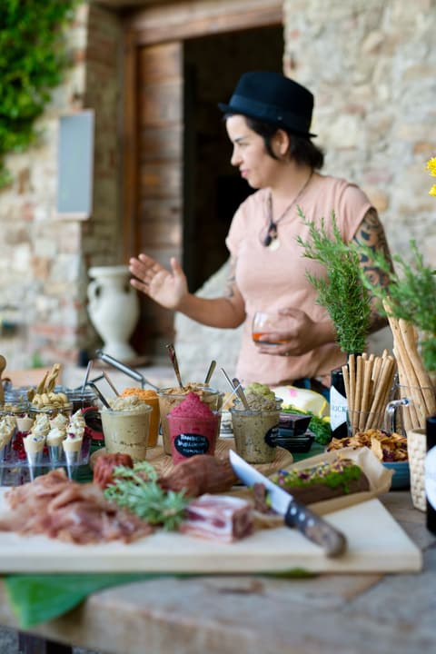 Lia am Buffet mit Aufschnitt, Käse und Brot vor einer alten Steinmauer